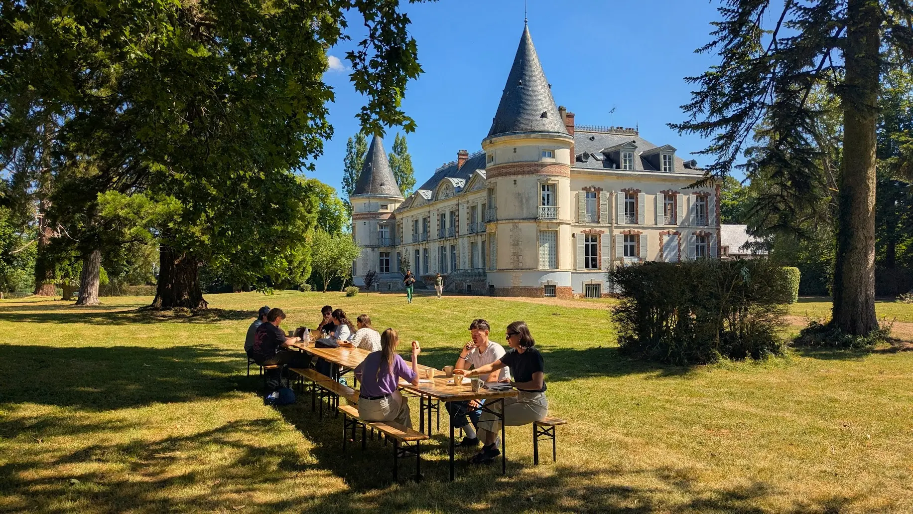 Un groupe à table dans le jardin du château de Chenevelle